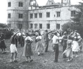Ein altes Foto von 1953 auf dem viele Paare Volkstänze vor der zerstörten Wewelsburg aufführen.
